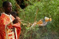 Kenyan priest censing the faithful.