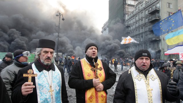 Orthodox priests pray during the protests (Pic: EPA)