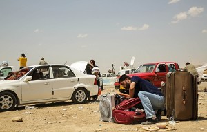A man leaves his car and packs his bag at the Khazair checkpoint after fleeing from Mosul, Iraq on June 11, 2014. Credit: R. Nuri UNHCR/ACNUR via Flickr (CC BY-NC-SA 2.0).