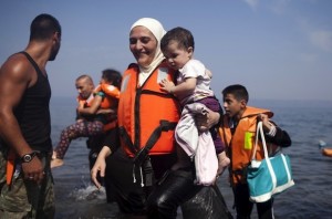 A Syrian refugee holds a child moments after arriving on a dinghy on the Greek island of Lesbos, September 3, 2015. Greece will ask the European Union for about 700 million euros to build infrastructure to shelter the hundreds of refugees and migrants arriving on its shores daily, the government said on Thursday. The cash-strapped country has seen a rise in the number of refugees and migrants -- mostly from Syria, Iraq and Afghanistan -- arriving on rubber dinghies from nearby Turkey. REUTERS/Dimitris Michalakis - RTX1QXN1