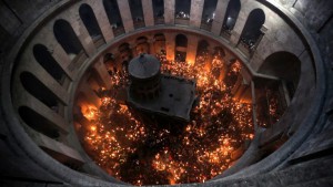 Christian Orthodox worshipers hold up candles lit from the ‘Holy Fire’ as thousands gather in the Church of the Holy Sepulcher in Jerusalem’s Old City, on April 11, 2015. (AFP/Ahmad Gharabli)