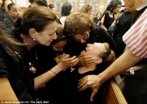 Grief: Friends and relatives comfort the elderly grandmother of air hostess Yara Hani Tawfik at her memorial service in a Cairo church